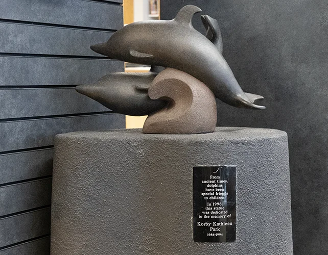 View of the dolphin statue with its plaque visible.