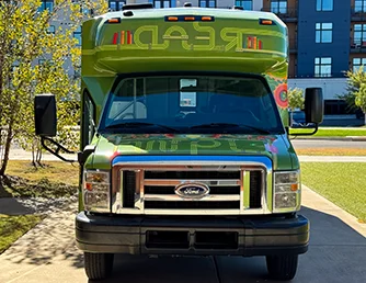 The Book Bus, viewed from in front, parked outside the Advanced Learning Library